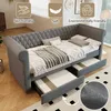 A grey upholstered daybed with two pull-out drawers underneath, set in a room with wooden flooring and a patterned rug. Produktbild-Vorschau