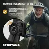 An older man is riding a stationary bike outdoors, with a close-up of the bike's tension control knob. Produktbild-Vorschau