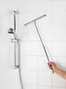A hand holding a telescopic squeegee in a shower stall with white tiled walls. Produktbild-Vorschau