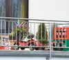 A balcony with a red toy car, plants, and a crate of drinks. Produktbild-Vorschau