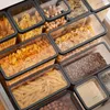 A close-up view of various food storage containers filled with different dry goods, neatly organized in a drawer. Produktbild-Vorschau