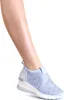 A person's leg wearing a blue wedge sneaker.