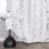 A close-up view of a white curtain with a silver marble pattern, draped over a small table with a book and a cup. Produktbild-Vorschau