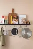 A kitchen shelf with cooking books, a cutting board, and pots hanging below. Podgląd zdjęcia produktu