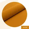A close-up, angled view of a rolled piece of textured fabric in a deep golden yellow or mustard color, presented within a white circular border. Anteprima dell’immagine prodotto