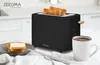 A black toaster with toast in it, a plate of toast, and a mug of tea on a kitchen counter. Produktbild-Vorschau