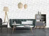 A living room scene featuring a teal sofa, coffee table, armchair, and a shelving unit against a textured white wall. Produktbild-Vorschau