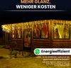 A wooden cabin decorated with icicle lights at night. Produktbild-Vorschau