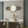 A modern dining room with a large decorative wall clock above a marble-top dining table. Produktbild-Vorschau