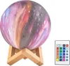 A galaxy-themed moon lamp on a wooden stand next to its remote control. Anteprima dell’immagine prodotto