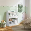 A child's bedroom with a white bookshelf filled with books and toys, a decorative wall hanging, and a bed with striped bedding. Produktbild-Vorschau