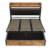 A bed frame with a slatted base, a padded headboard, and a wooden shelf above the headboard. The bed frame has a wooden exterior and a black interior. Produktbild-Vorschau