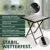 A square folding table with a wood-look top on a balcony or patio. The image includes icons and text highlighting the product's features. Produktbild-Vorschau