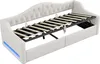 A white upholstered daybed with a slatted mattress support frame extended upwards, revealing storage space underneath. Blue LED lighting is visible along the bottom front edge of the daybed. Náhled obrázku produktu