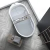 A modern bathroom scene with a freestanding bathtub filled with water, a wooden tray with toiletries, and a small wooden stool with a folded towel and decorative balls. Produktbild-Vorschau