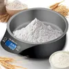 A digital kitchen scale with a bowl filled with flour, surrounded by wheat stalks and a bowl of flour. Produktbild-Vorschau