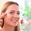 A woman is applying a face lift sticker to her face, with a close-up inset showing the product. Náhled obrázku produktu
