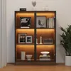 A well-lit display cabinet with glass doors, showcasing various decorative items and books on its shelves. The cabinet is illuminated by warm LED lights. Náhľad obrázku produktu