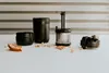 A disassembled tea infuser and a piece of bread are laid out on a white surface with a striped background. Podgląd zdjęcia produktu