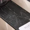 A close-up of a black marble-patterned surface. Podgląd zdjęcia produktu