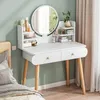 A white vanity table with a mirror, set up in a bedroom next to a bed. It's adorned with various cosmetic products and a small vase with a plant. Anteprima dell’immagine prodotto