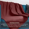 A red blanket draped over a blue sofa. Náhľad obrázku produktu