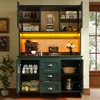 A green kitchen cabinet with various items stored inside, including food, appliances, and cookware. The cabinet has doors and drawers, and is illuminated by yellow LED lighting. Náhľad obrázku produktu