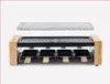 A raclette grill with a granite stone top and eight individual pans, presented against a plain white background. Produktbild-Vorschau