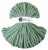 A ball of green yarn with a white label around the middle. Náhled obrázku produktu