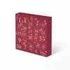 A close-up, angled view of a red advent calendar with gold numbering and festive graphics, set against a white background. Anteprima dell’immagine prodotto