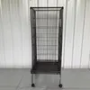 A tall, black metal bird cage with wheels stands in front of a white corrugated metal wall. Náhled obrázku produktu