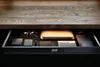 An open desk drawer containing various office supplies. Podgląd zdjęcia produktu