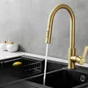 A kitchen sink with a gold faucet running water into it. There are two decorative jars in the background. Produktbild-Vorschau