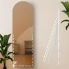 A full-length arched mirror is shown in a room setting with a plant and a small cabinet. Produktbild-Vorschau