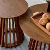 Two round wooden coffee tables of different sizes, one with a tray of peaches on it. Produktbild-Vorschau