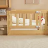 A close-up view of a wooden crib with white stuffed animals inside, placed on a carpeted floor. Produktbild-Vorschau