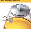 A close-up view of a glass teapot filled with yellow liquid, likely tea, with a silver lid and a spiral-shaped infuser visible. Produktbild-Vorschau