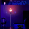 A desk setup with a lamp, headphones, and a monitor, illuminated by ambient purple and pink lighting. Produktbild-Vorschau