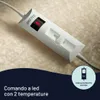 Close-up of a white electric blanket controller with a red LED light and a slider switch, placed on a cream-colored textured surface. A dark blue overlay at the bottom contains text and a circular icon. Anteprima dell’immagine prodotto