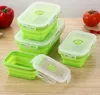 A set of green silicone food storage containers with clear lids are arranged on a wooden surface, with a red bell pepper and a tomato in the background. Náhled obrázku produktu