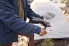 A person is using a Lifestraw water filter in front of a tent. Produktbild-Vorschau