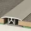 A close-up view of a flooring transition profile, showing its cross-section and how it connects two different flooring materials. Produktbild-Vorschau