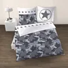 A bed with camouflage bedding and star-themed pillows. Produktbild-Vorschau