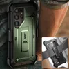A dark green phone case with a kickstand and belt clip is shown attached to a person's belt. Náhľad obrázku produktu