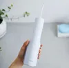 A hand holding a white Panasonic water flosser. Produktbild-Vorschau
