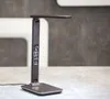 A modern desk lamp with a digital display sits on a textured surface. Náhled obrázku produktu