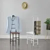 Two valet stands in a room, one with a blue shirt and a hat on the wall, the other with scarves draped over it. Anteprima dell’immagine prodotto