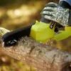 A person wearing gloves is using a yellow electric chainsaw to cut a tree branch. Produktbild-Vorschau