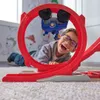 A young boy is playing with a toy car track, laughing as a toy car goes through a loop. Náhľad obrázku produktu
