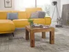 A living room scene with a yellow sofa, a wooden coffee table, and decorative items. Produktbild-Vorschau